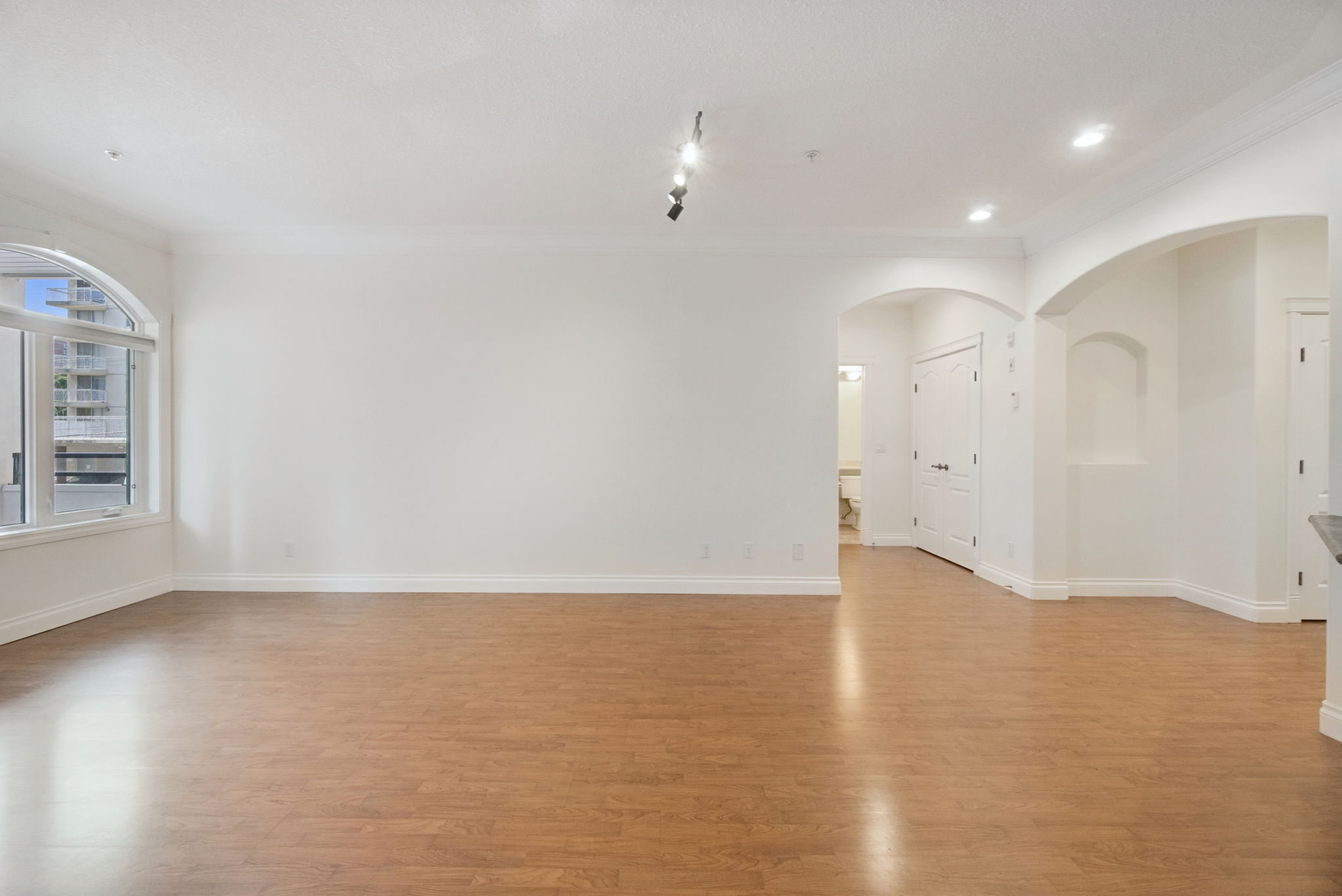 Looking back across the living room toward the arched openings to the foyer and hallway.