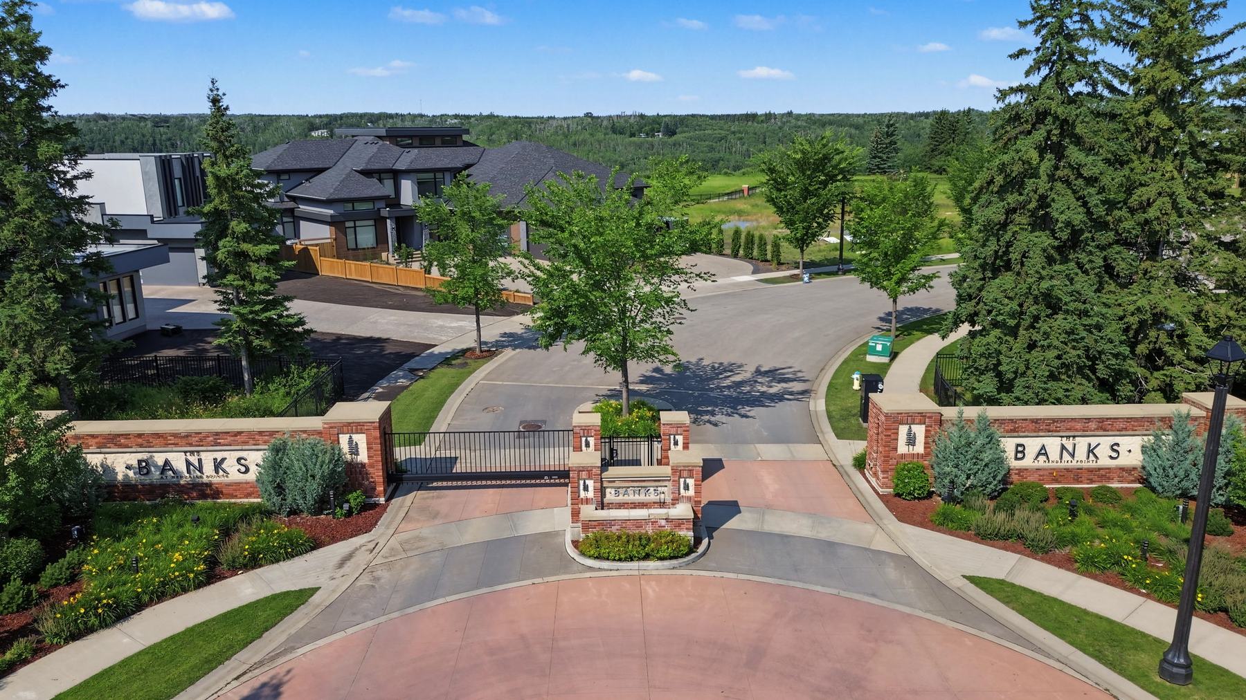 The gated entry to The Banks, with brick pillars and the Banks lettering on either side of the drive.