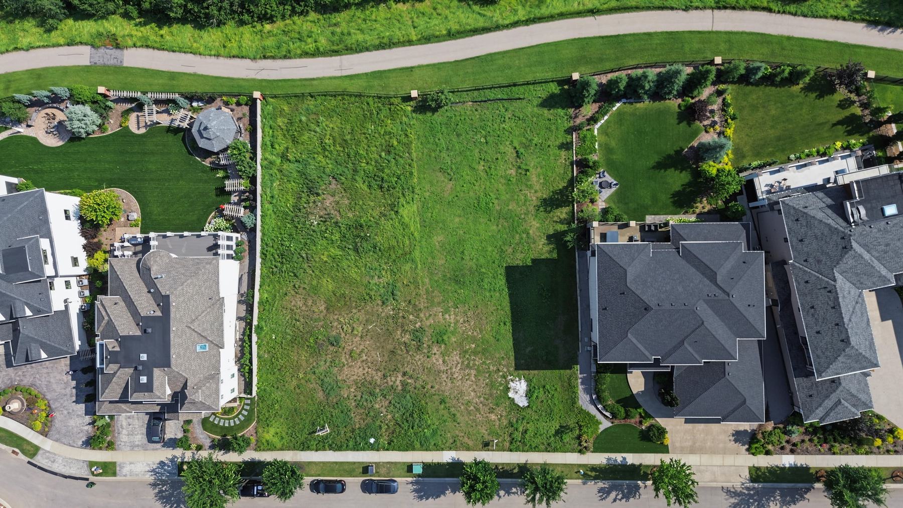 Overhead view of Lot 6, an open grass lot between two completed estate homes on Keswick Boulevard.