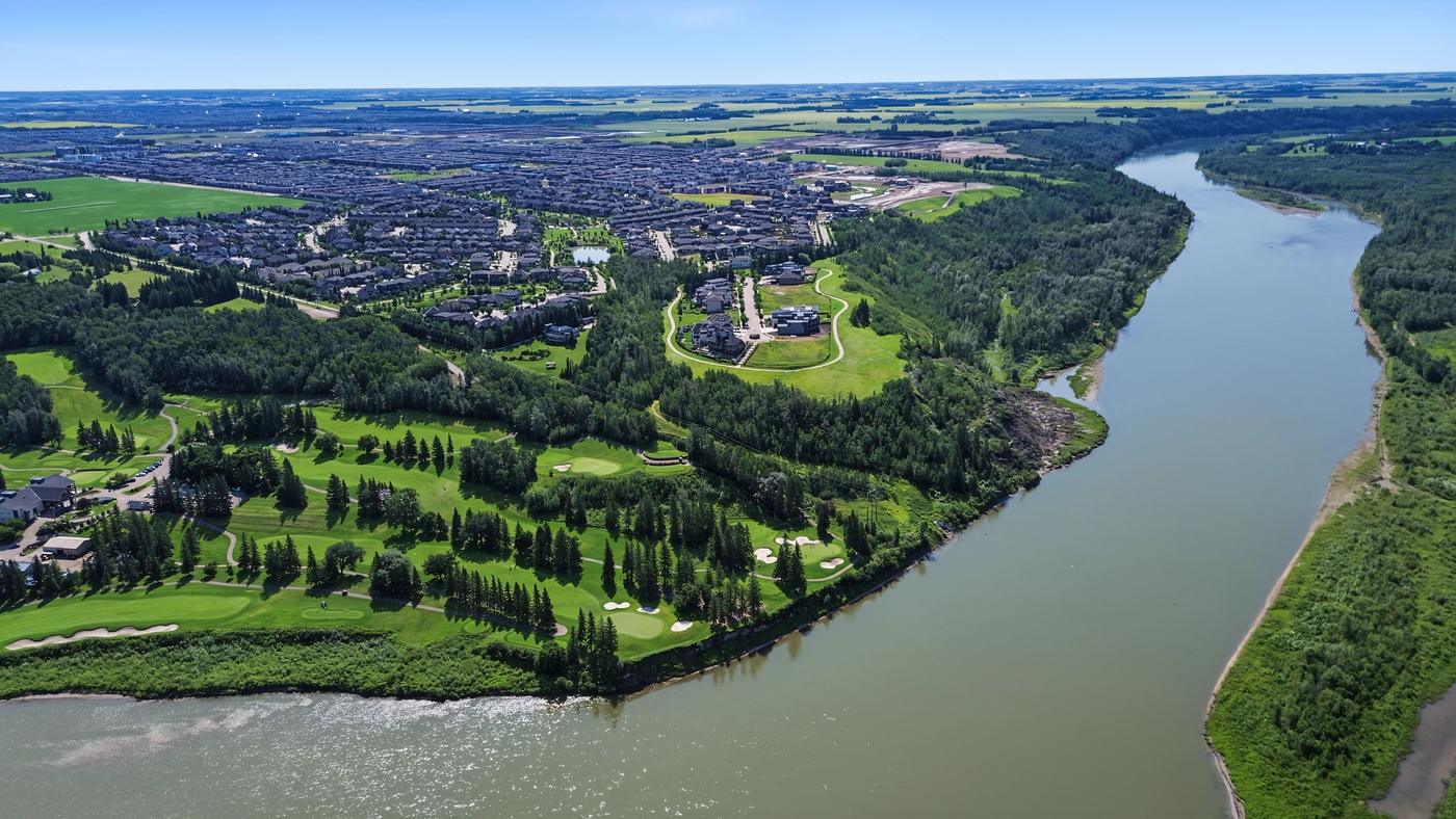 A bend in the North Saskatchewan River with a sandbar and wooded banks.